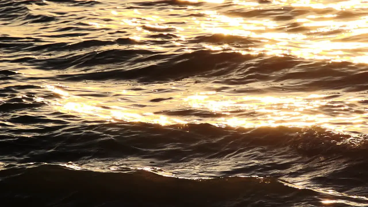 Slow Motion Ocean waves glittering in the sunset