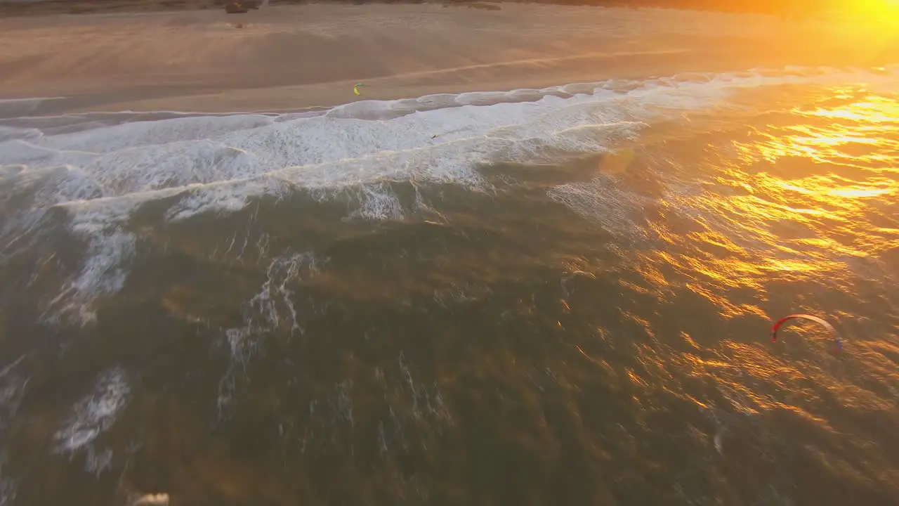 Close aerial shot of a kitesurfer jumping during sunset