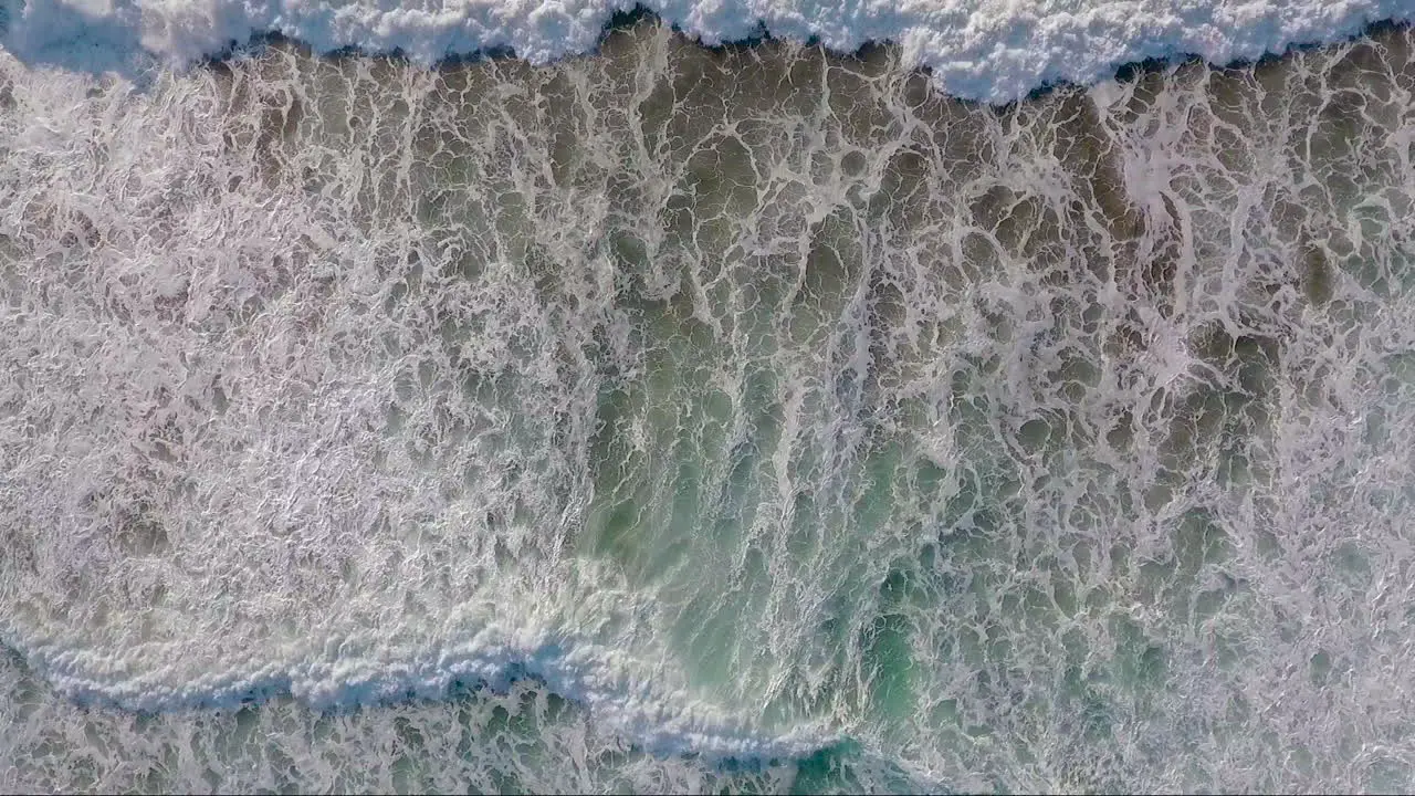 An very good aerial perspective looking straight down at the ocean with waves rolling in