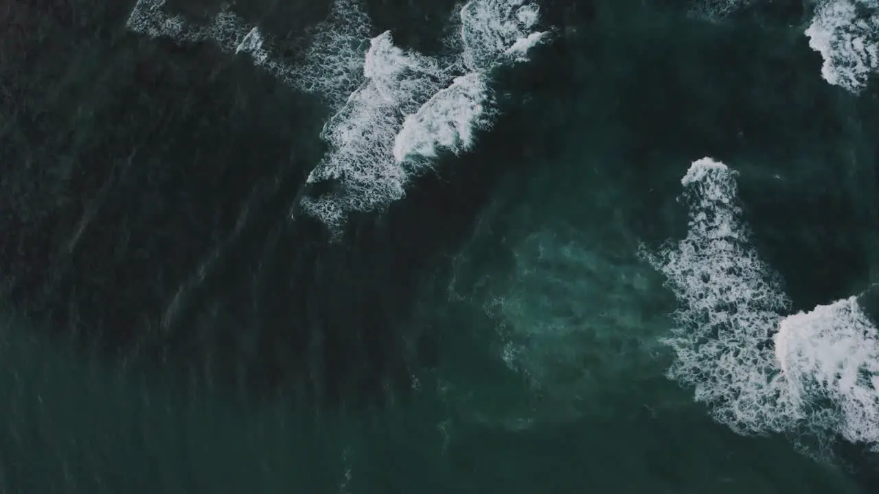 Aerial top down of crashing waves of blue Ocean in Costa Rica during summer