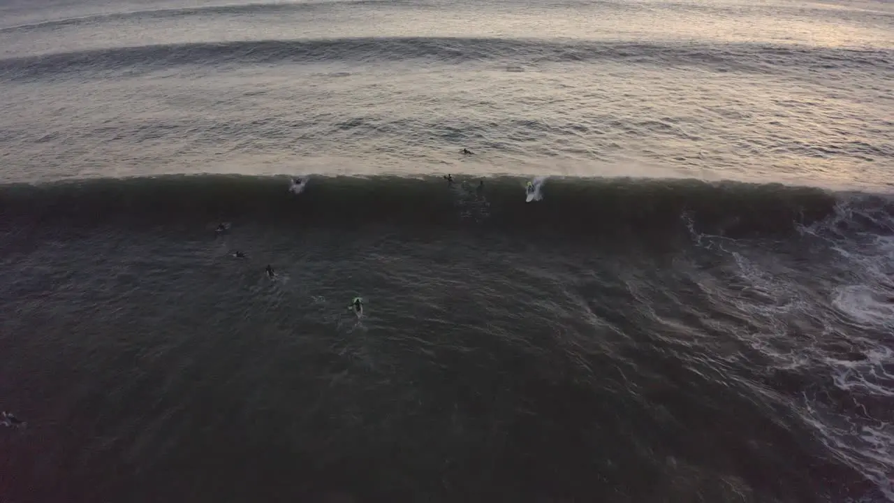 Aerial drone view of a group of surfers waiting for perfect waves on coast of Portugal