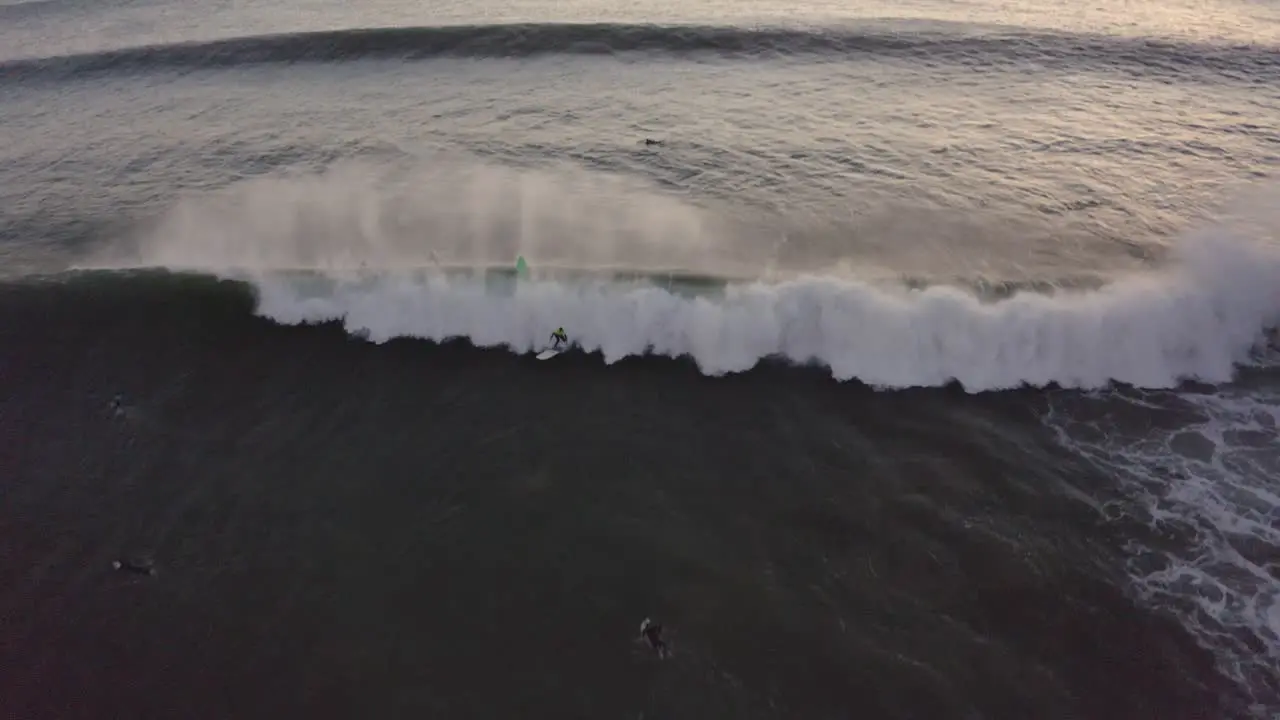 Aerial tilt up drone shot of waves on the atlantic sea at sunset in Praia sao pedro do estoril on a sunny evening in Cascais Portugal