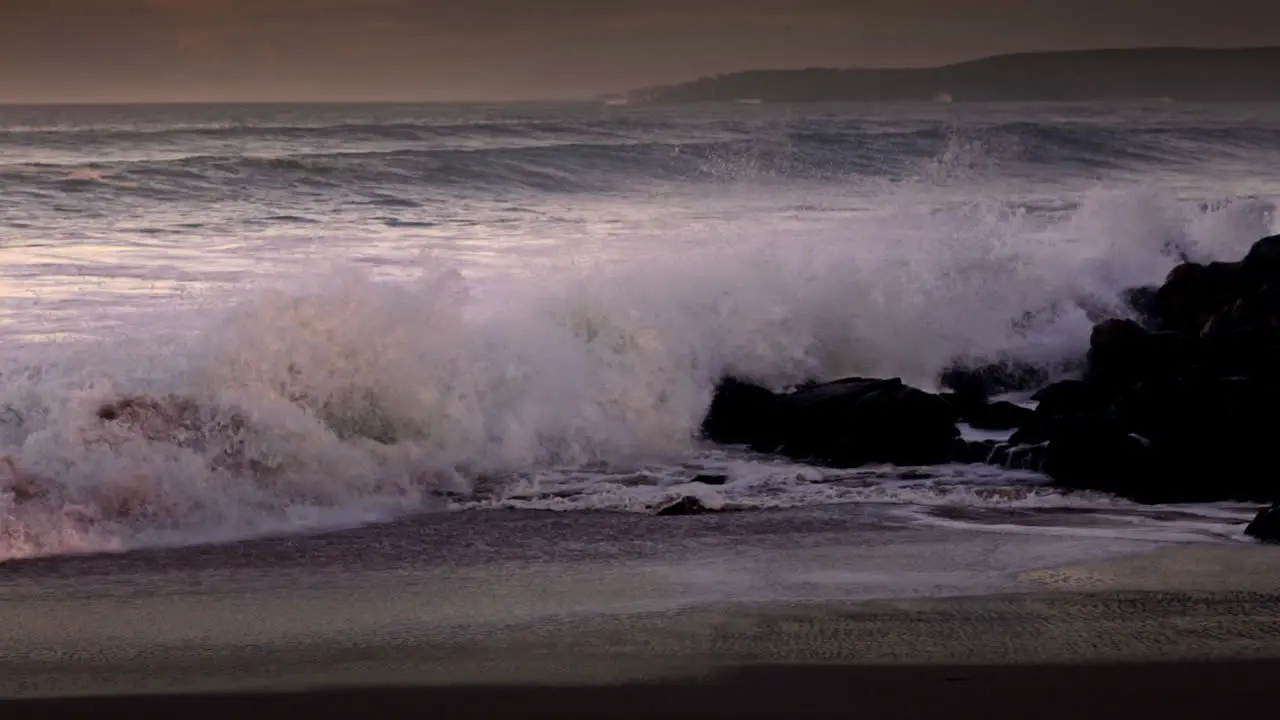 Waves roll into a beach following a big storm in slow motion 4