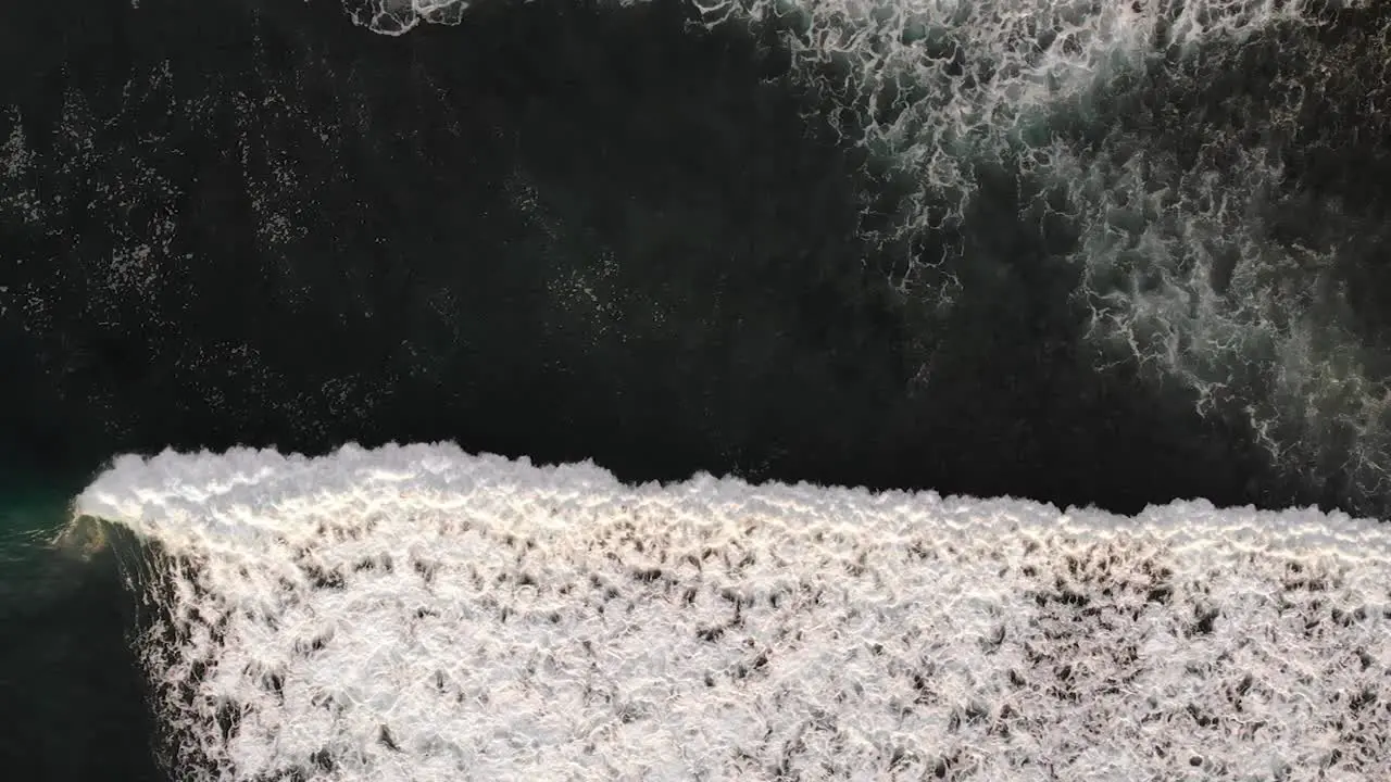 Aerial view of waves rolling through in Uluwatu Bali