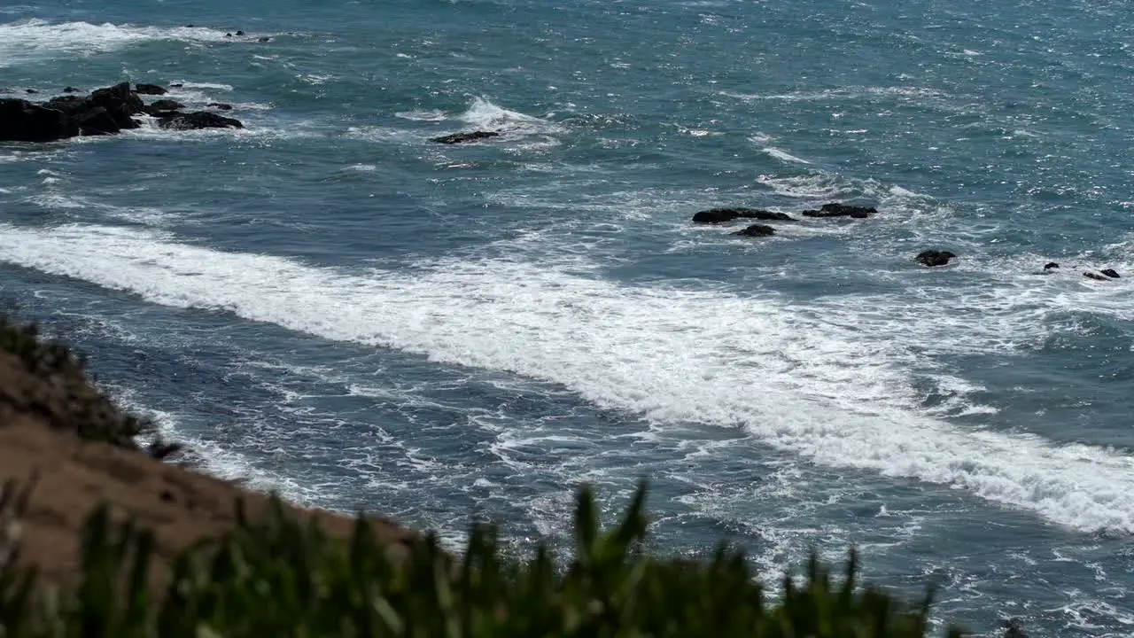 Waves rolling into a cliffside beach