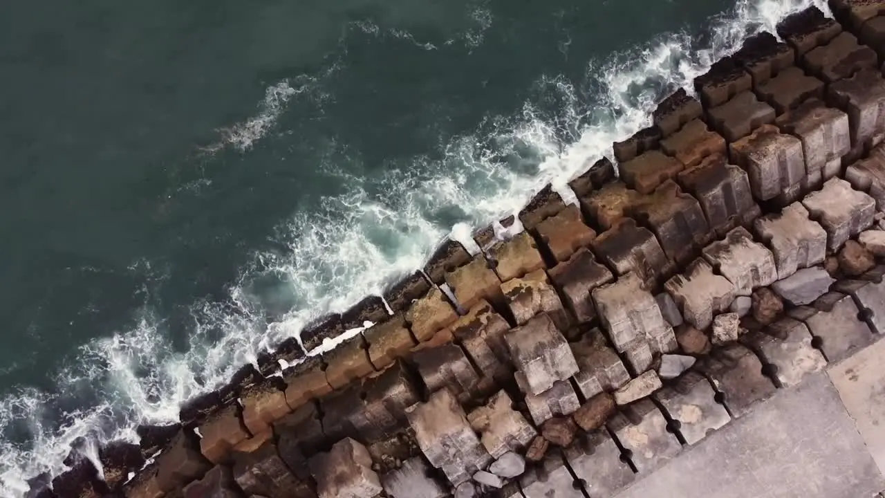 Drone Shot top view Waves hitting the pier