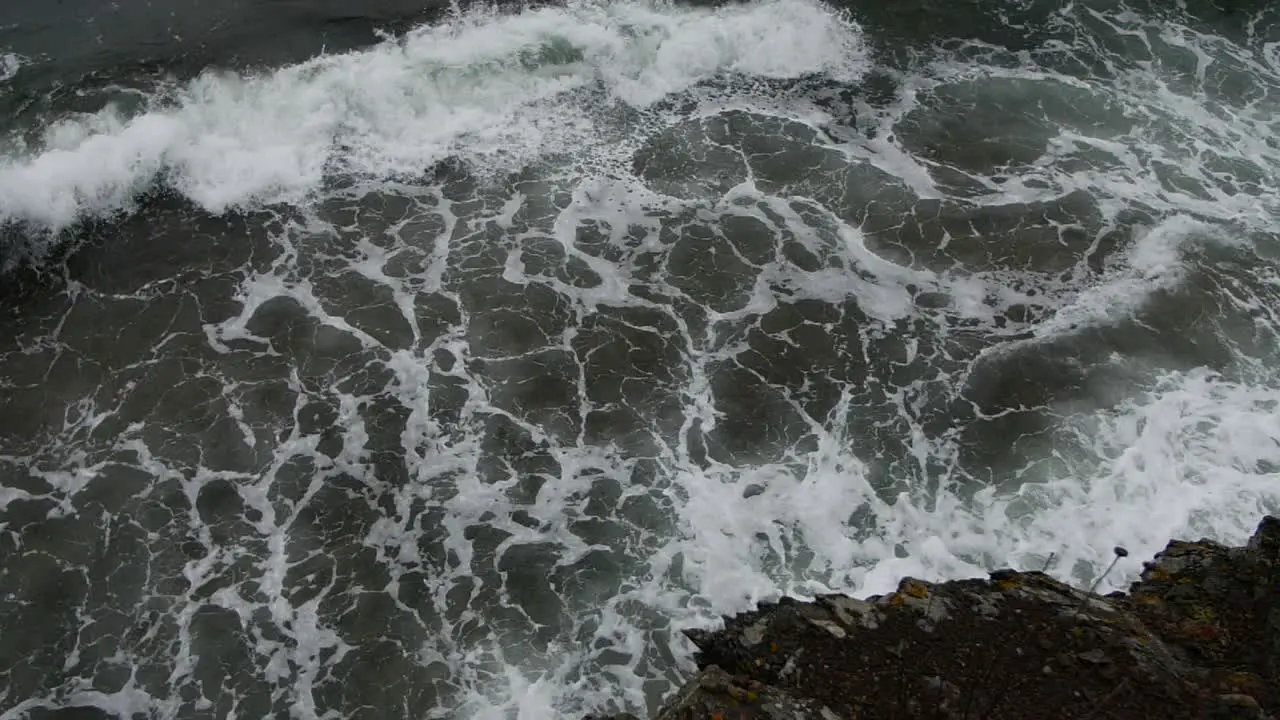 Cinematic wide shot from the rocks of a beauiful waves and foam