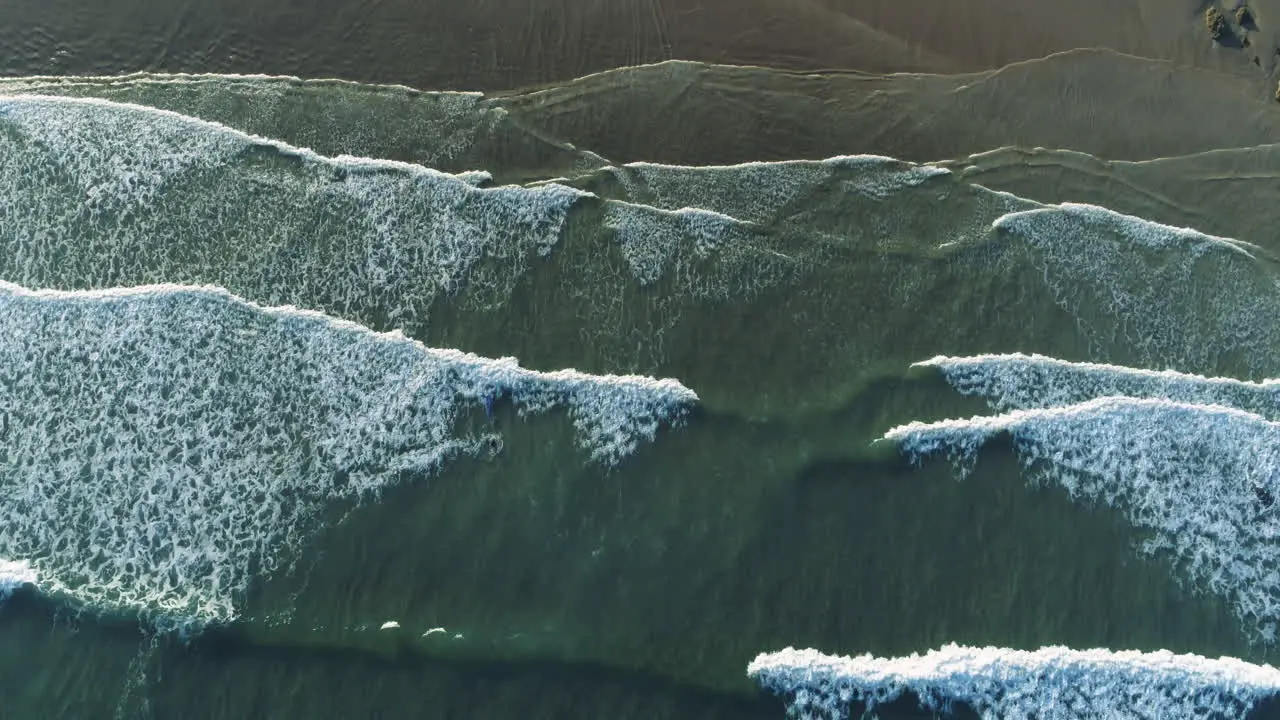 Arial shot of coastal waves moving up the frame