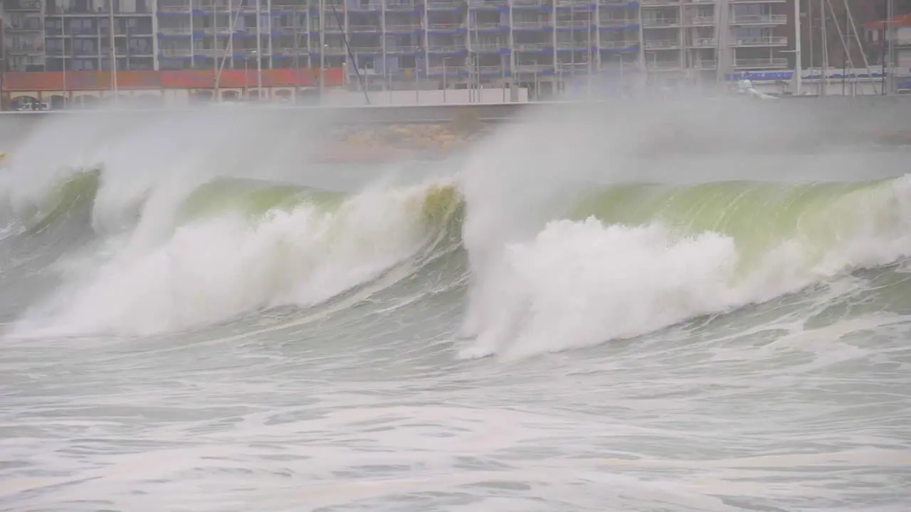 Giant wave in Super slow motion with the marina in the background breaking