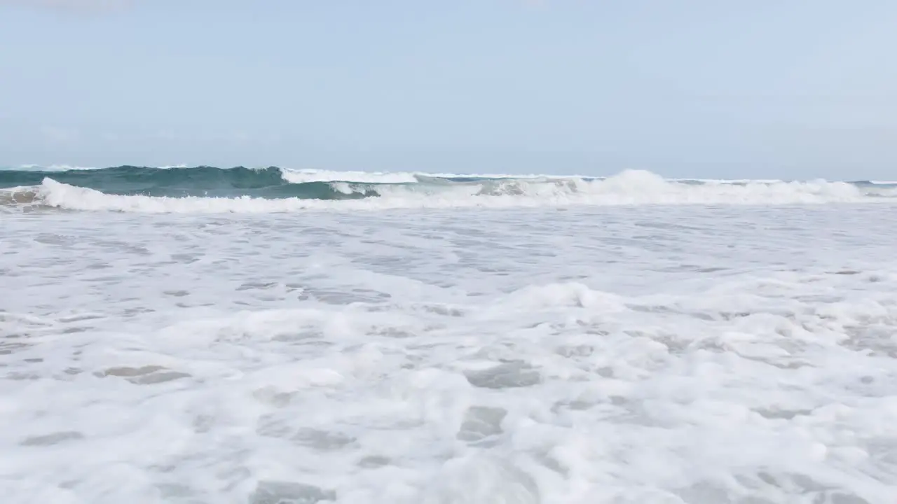 Waves coming onto a beach creating sea foam