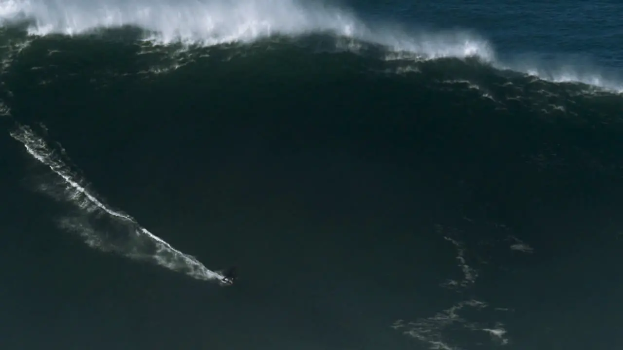 Slow motion of a big wave surfer riding a monster wave in Nazaré Portugal