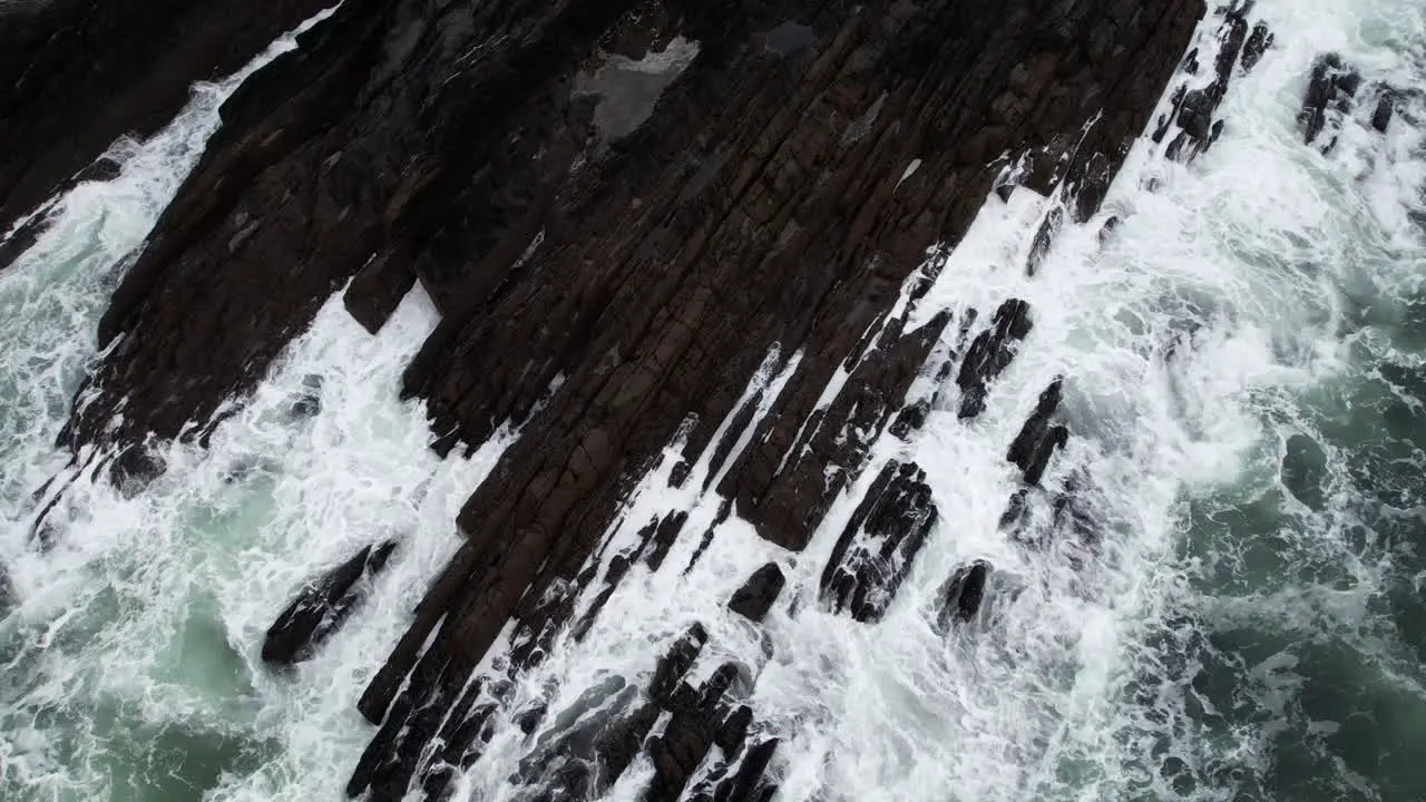 Top Down Aerial View of Ocean Waves Breaking on Rugged Coast of Ireland Birds Eye Drone Shot