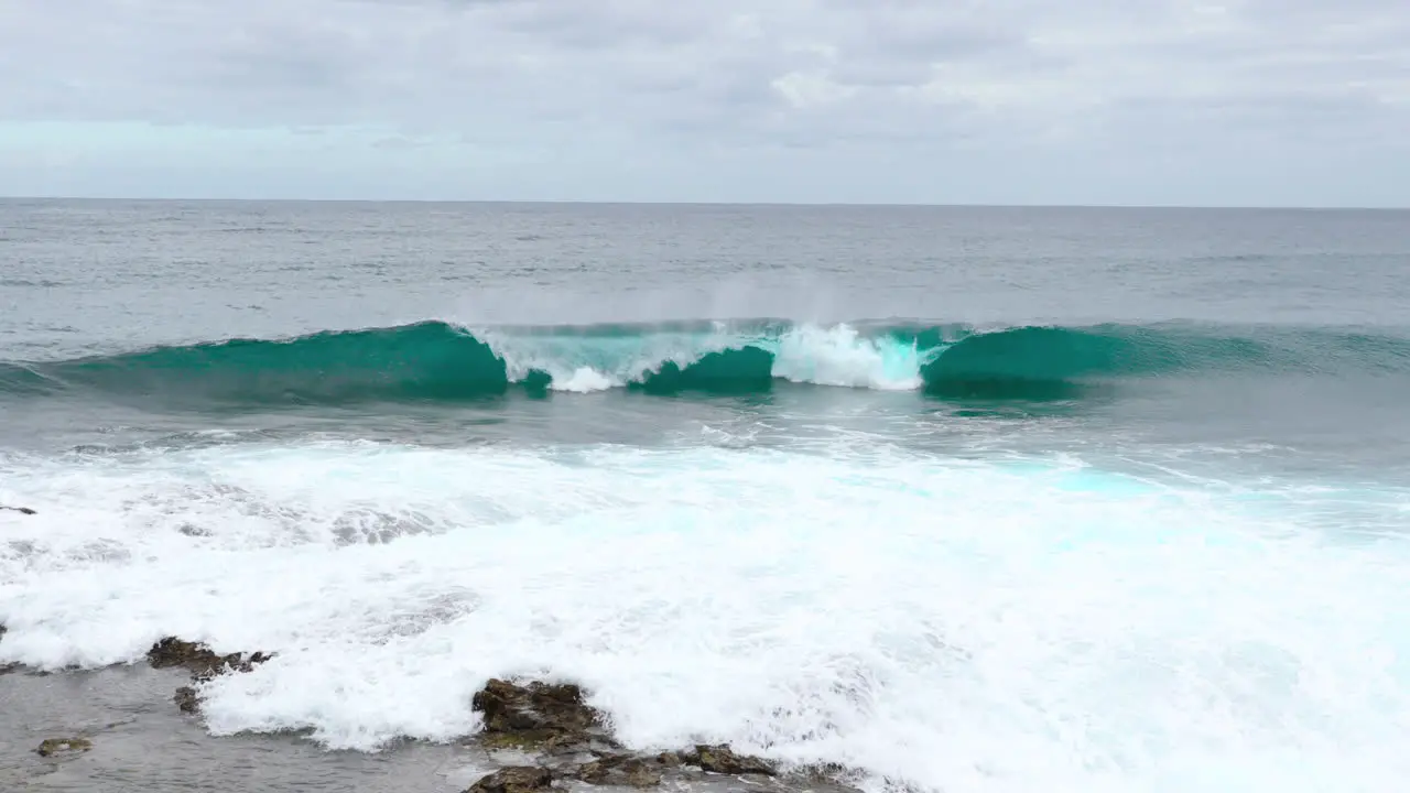 New wave emerging during cyan tide approaching the coastline captured by wide angle 4k slow motion capture at 60fps