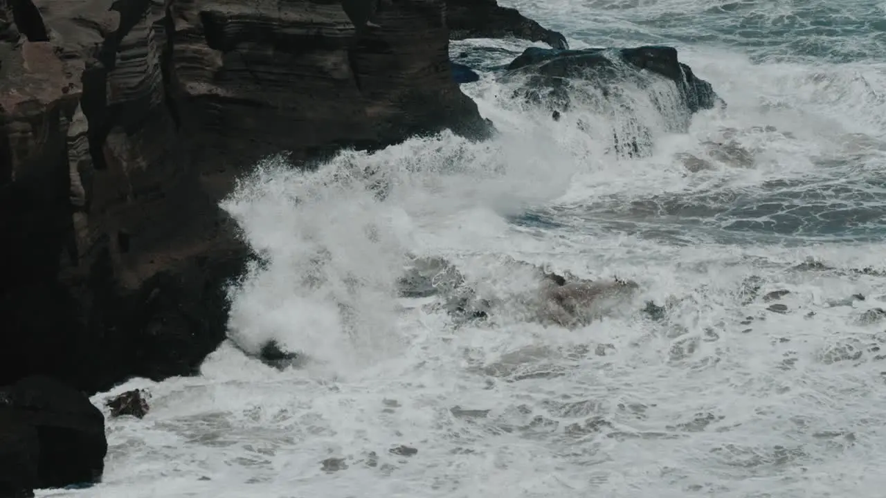 Waves crashing against rocks in slow motion