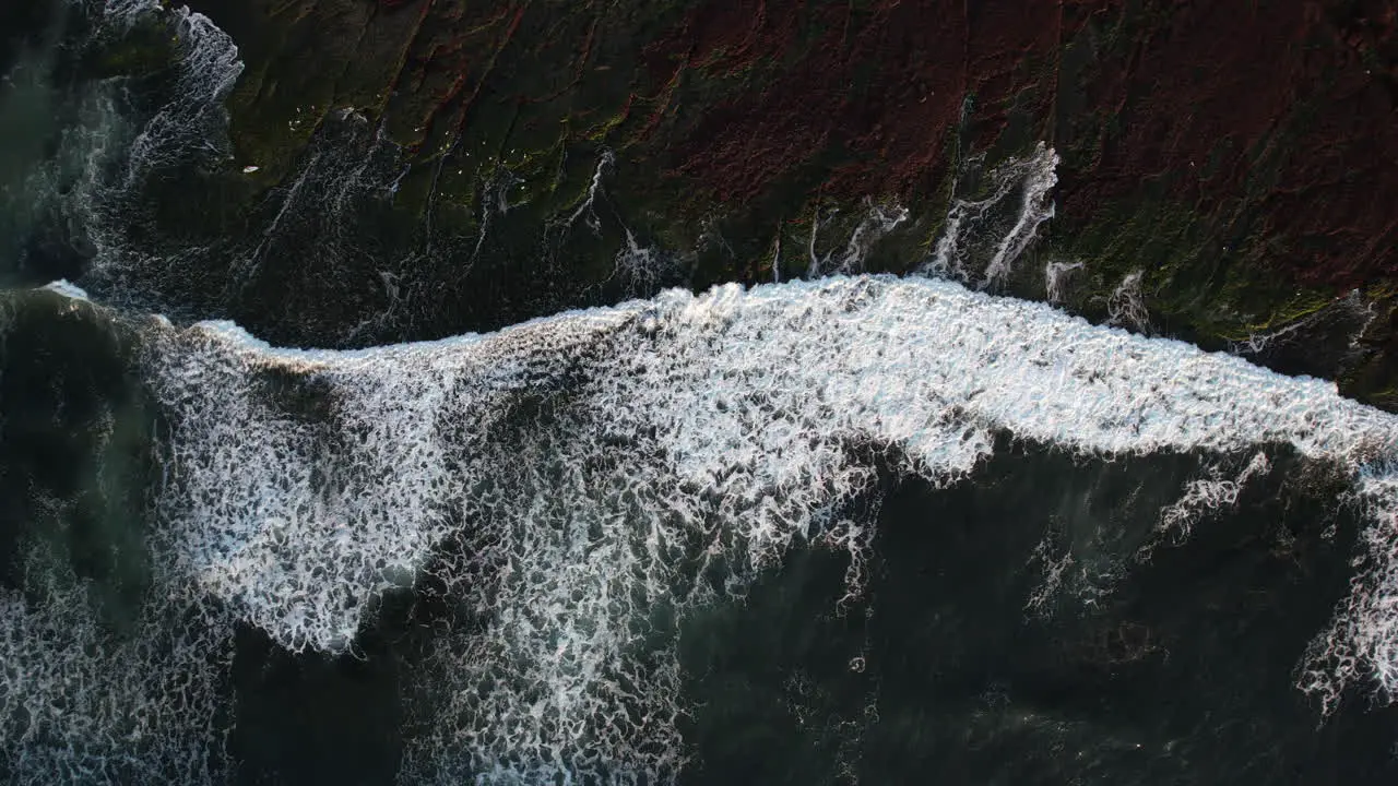 Top Down Aerial View Pacific Ocean Waves Breaking on Shore at Golden Hour Sun