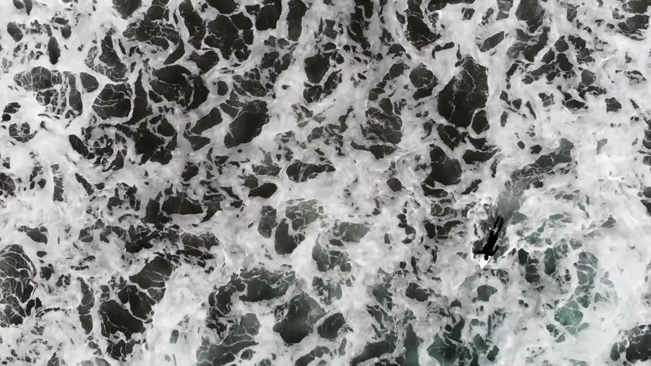 Slow motion guy paddling out to surf in the ocean