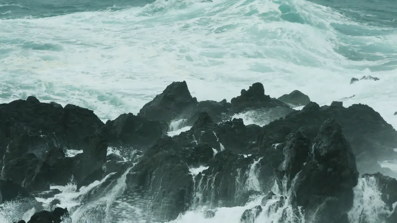 Dramatic close up of waves crashing over rocks