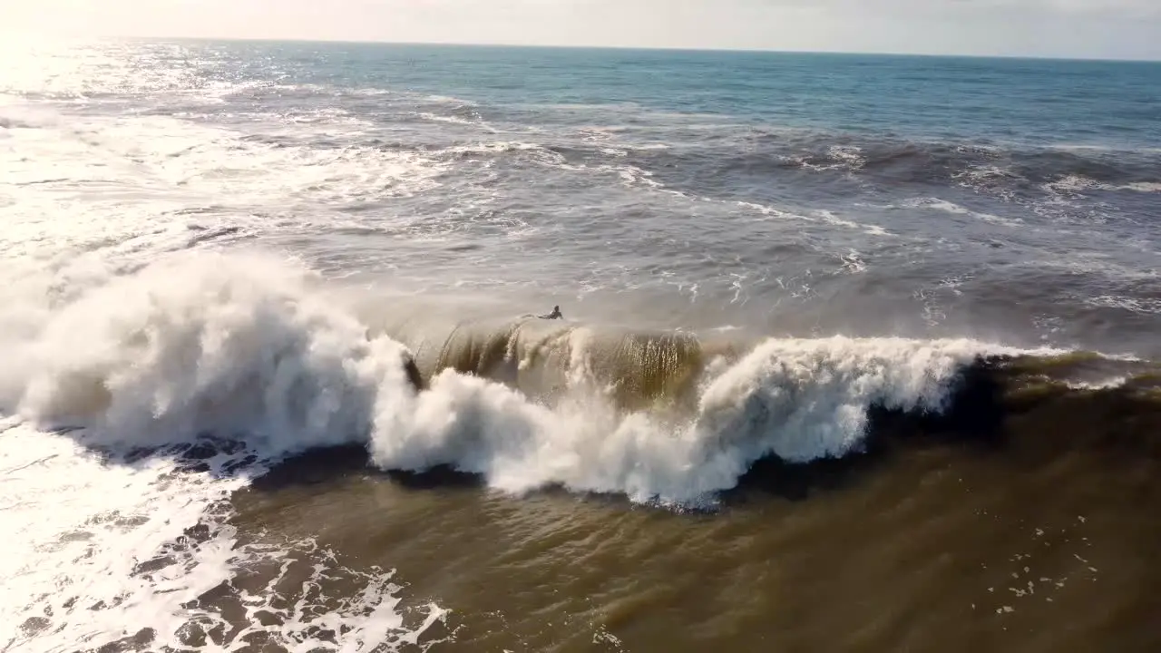 Aerial drone landscape shot of bodyboarder duck-dive stormwater wave foam swell Newcastle NSW Australia 4K