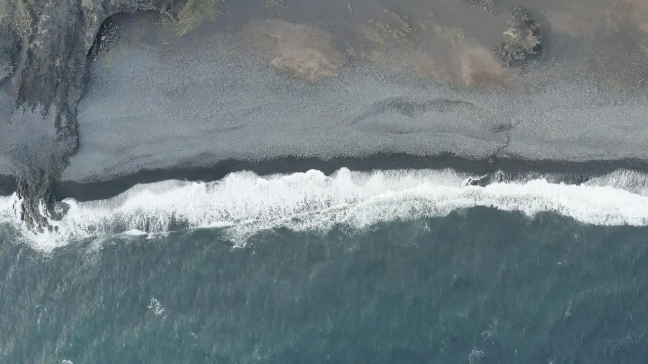 Puerto Rico aerial top down view of ocean waves crashing on black sand beach  tropical dreaming seascape paradise