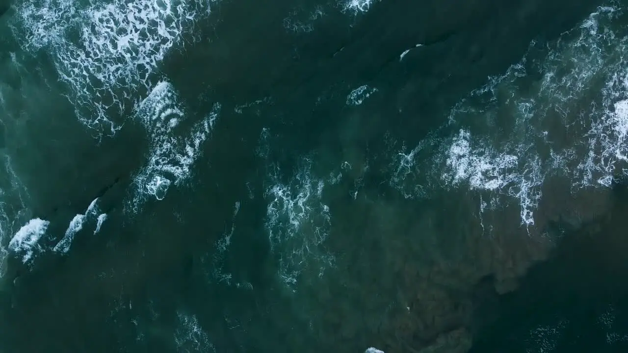 Aerial top down shot of the white foamy waters of the Indian Ocean as the waves and strong current wash up onto the beautiful beach in Sedgefield Western Cape South Africa