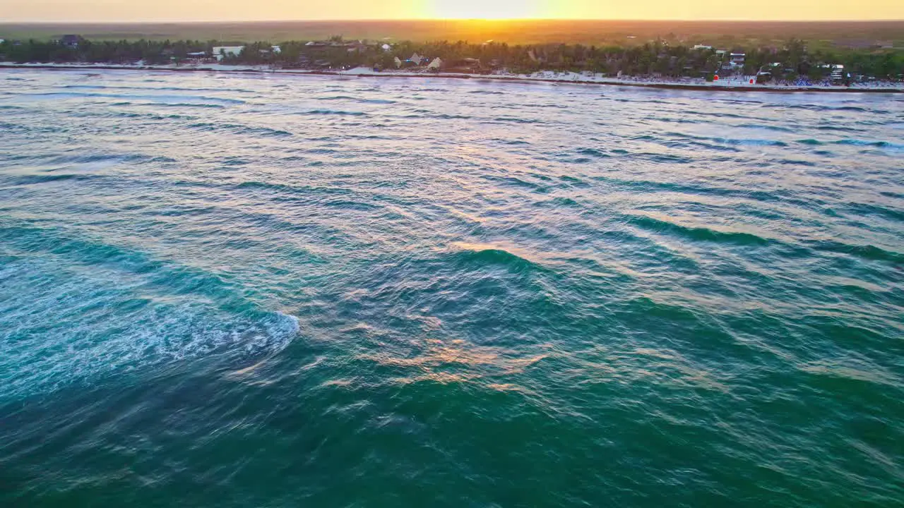 Drone Flying Over Vibrant Turquoise Blue Ocean Water Waves Near Carribean Beach In Mexico During Sunset