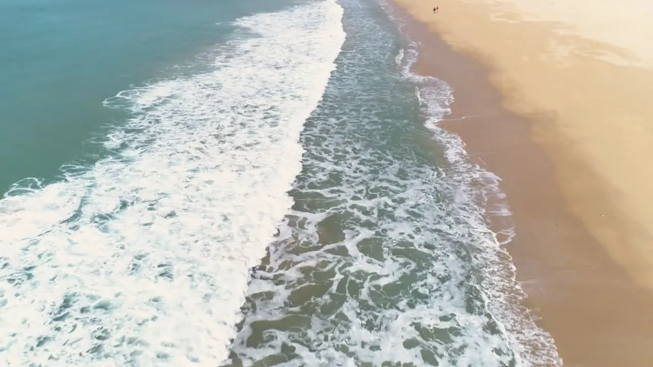 Aerial flying over the crashing waves on the coastline of Los Canos de Meca