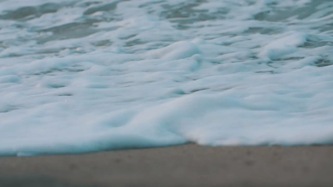 Waves crashing on the shore close-up macro view of foamy waves at the beach in slow -motion