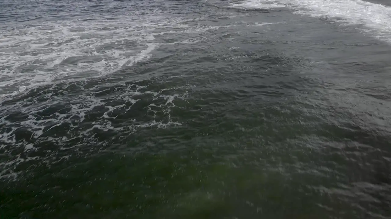 Aerial flyover shore break waves along sandy beach in Bali Indonesia