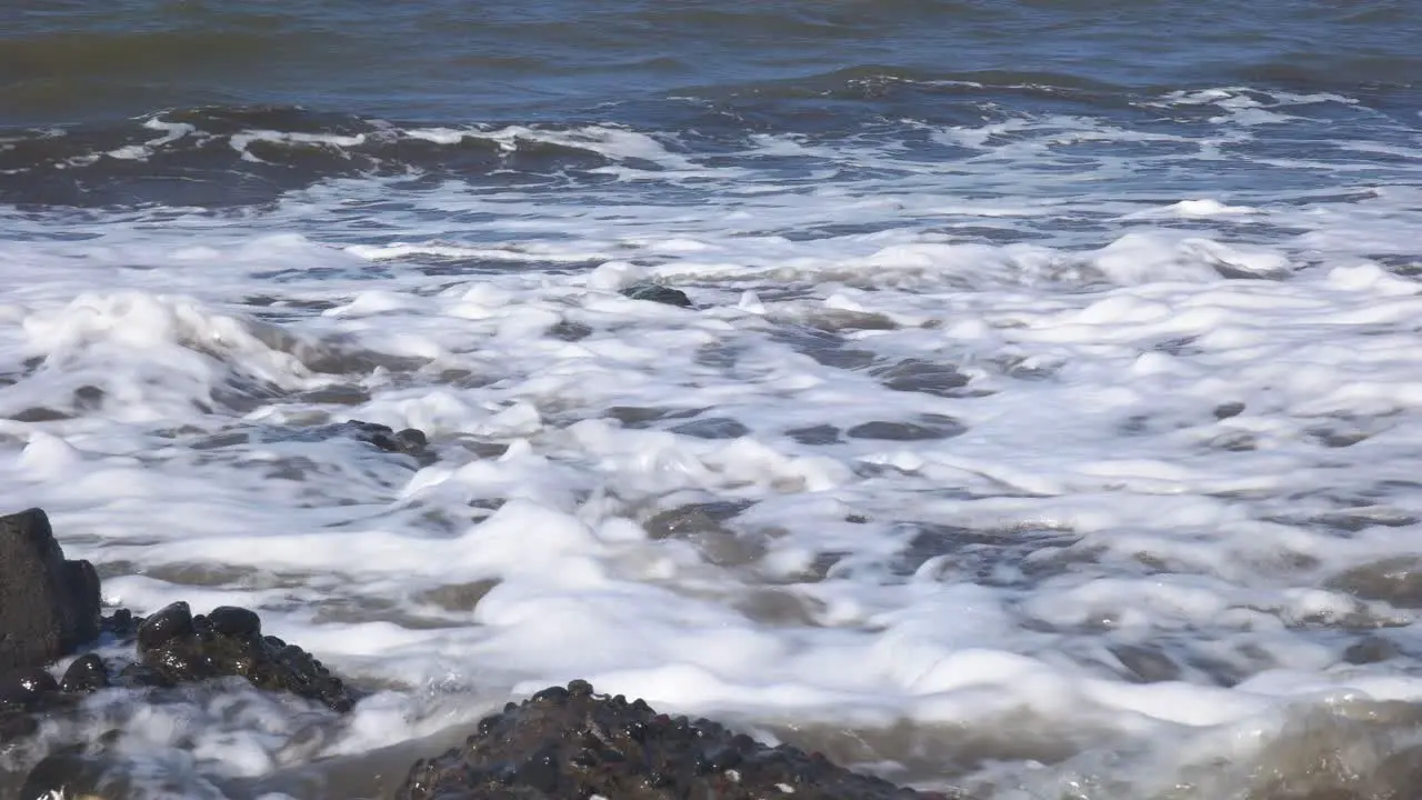 close-up of waves on the beach during the day