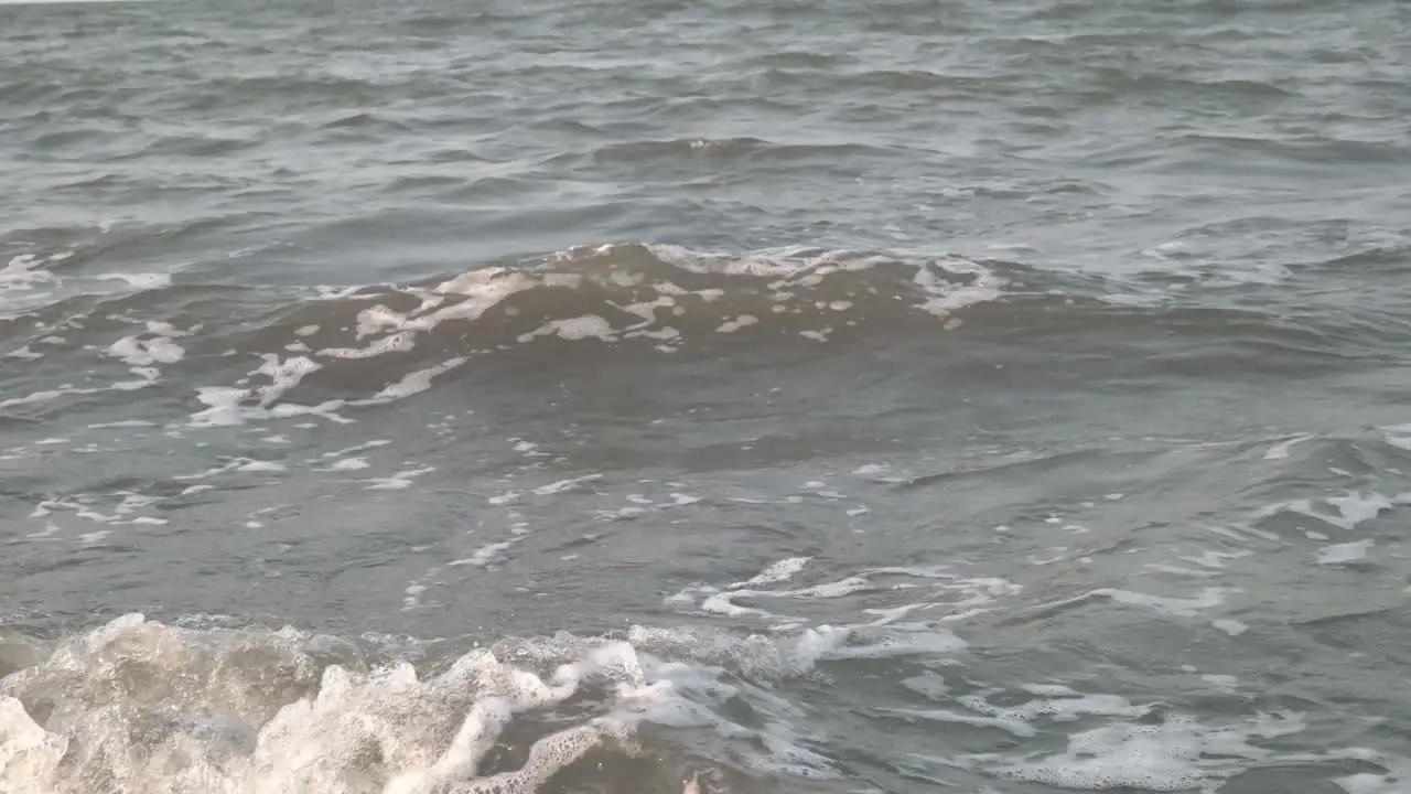 4k close up view of small waves on the beach