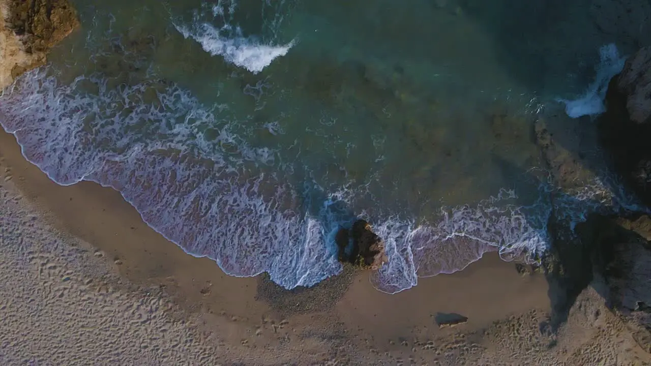 Slomotion aerial drone clip moving over a sandy beach and a rock formation in Kavala Macedonia Greece