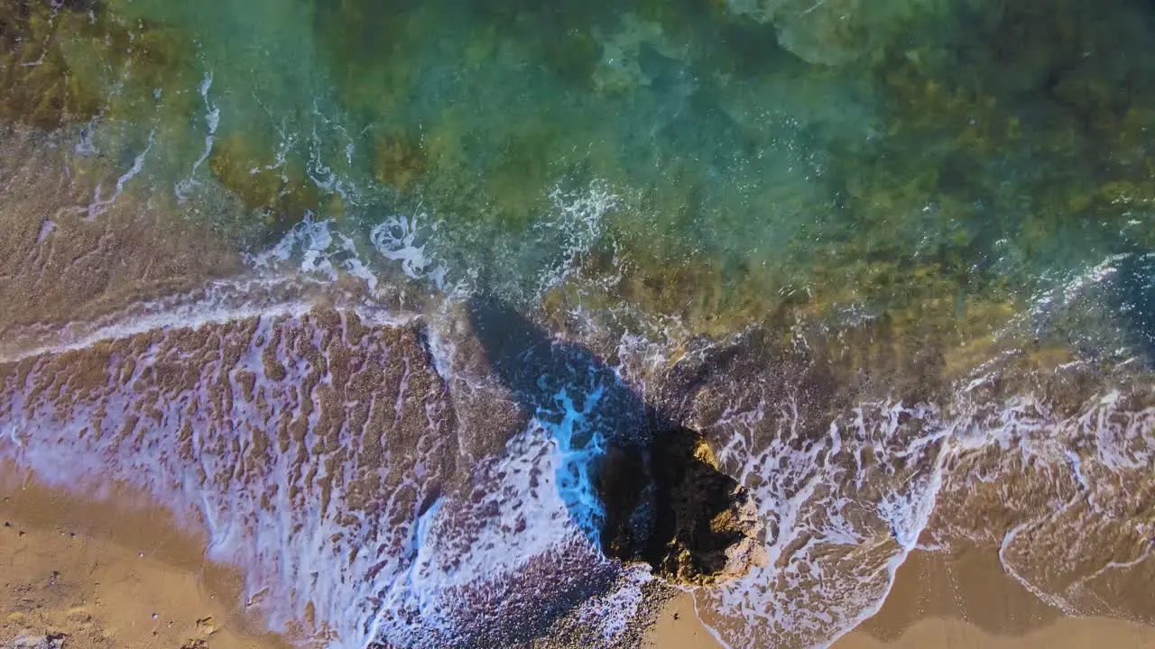 Taking off aerial drone clip moving over a sandy beach and a rock formation in Kavala Macedonia Greece