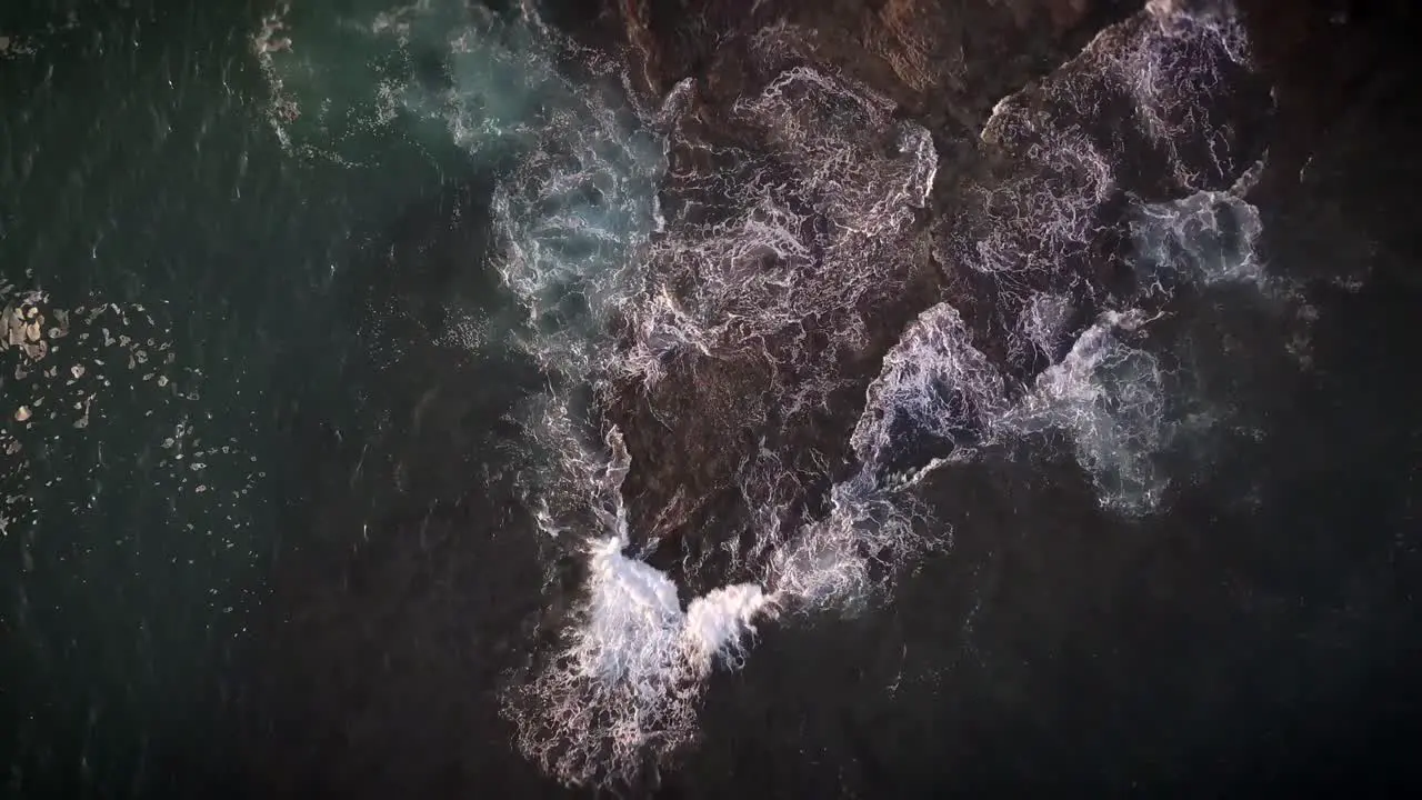 Waves breaking on rocks in California birds-eye view