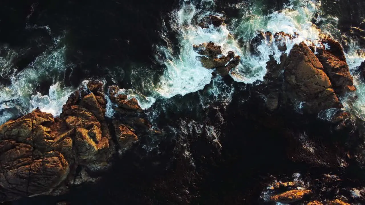 Waves crashing on rocks at sunset