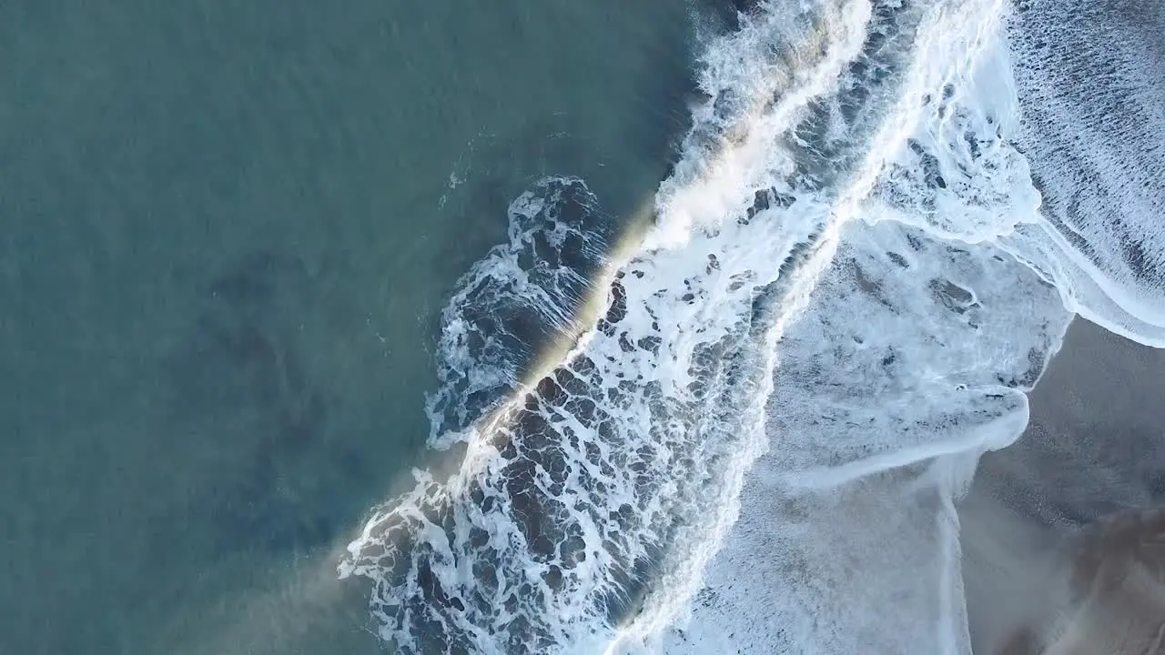 Cenital shot of the sea waves breaking on the beach resulting in foam Cariló Argentina