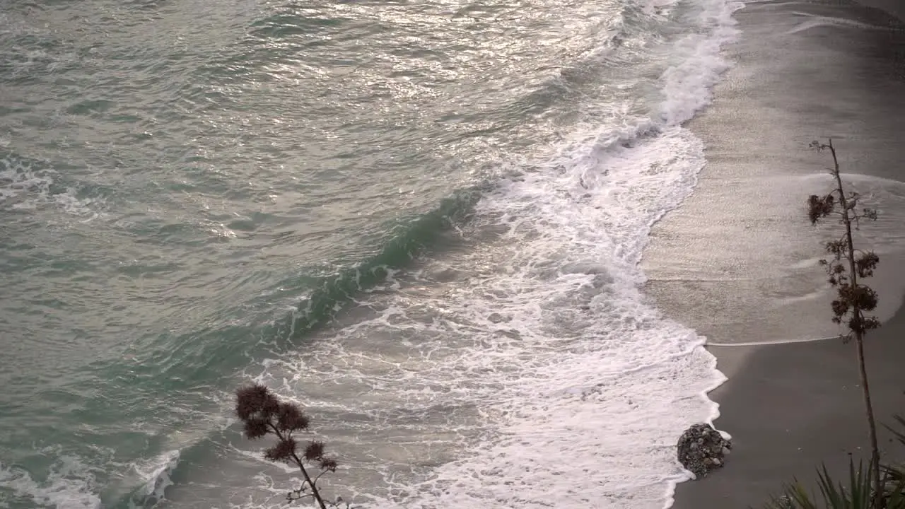 Looking down on beach during bad weather with crashing waves