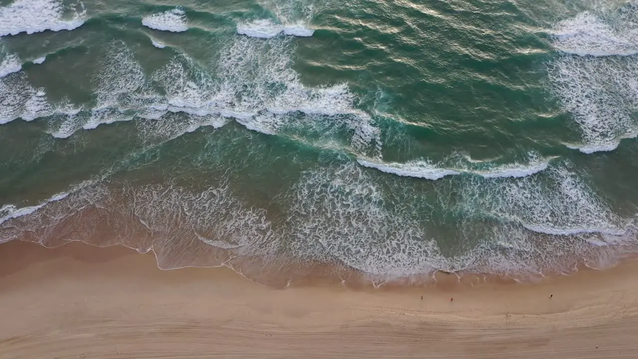 Early morning jogging along Surfers Paradise beach with wave rolling in