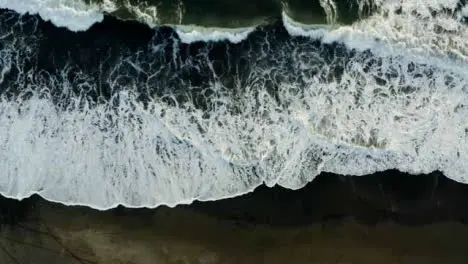 Drone Shot Looking Down On Waves at Pigstone Black Sand Beach