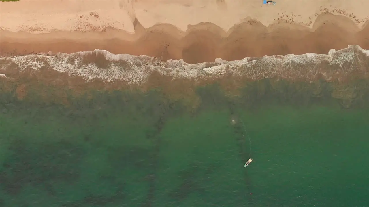 AERIAL boat in the beach and waves from above