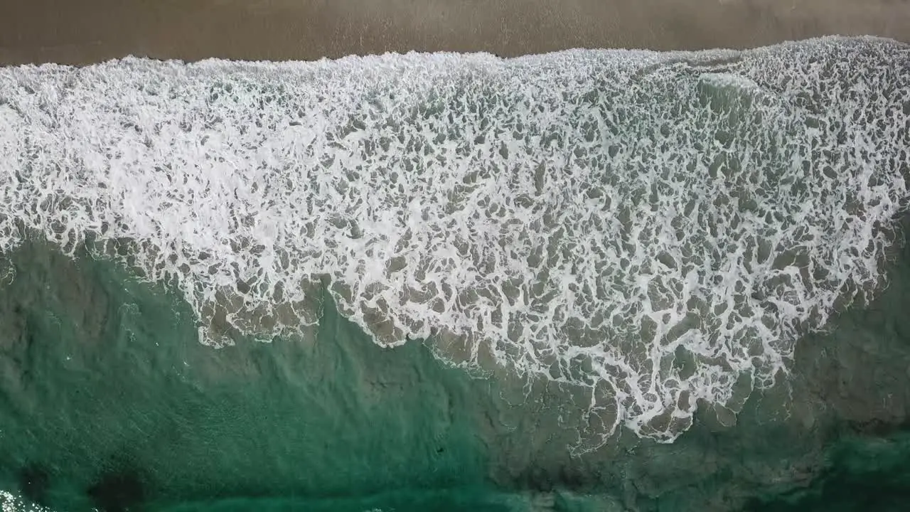 Water waves on brown sand