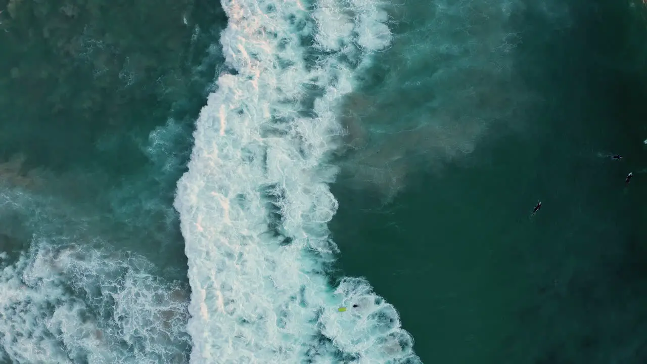 Vertical Shot Of Surfers On Llandudno Beach With Rolling Foamy Waves In Cape Town South Africa