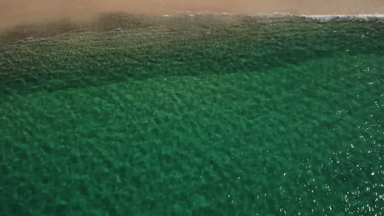 Aerial view of a beach in sunny Jervis bay NSW Australia reverse tilt drone shot