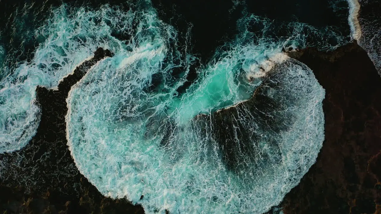 Crashing blue waves breaking in abstract texture on shore aerial boom up Oahu