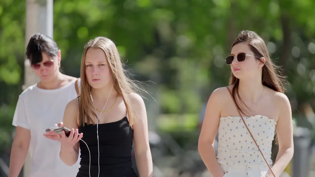 Close up telephoto shot in slow motion of teenage girls crossing street