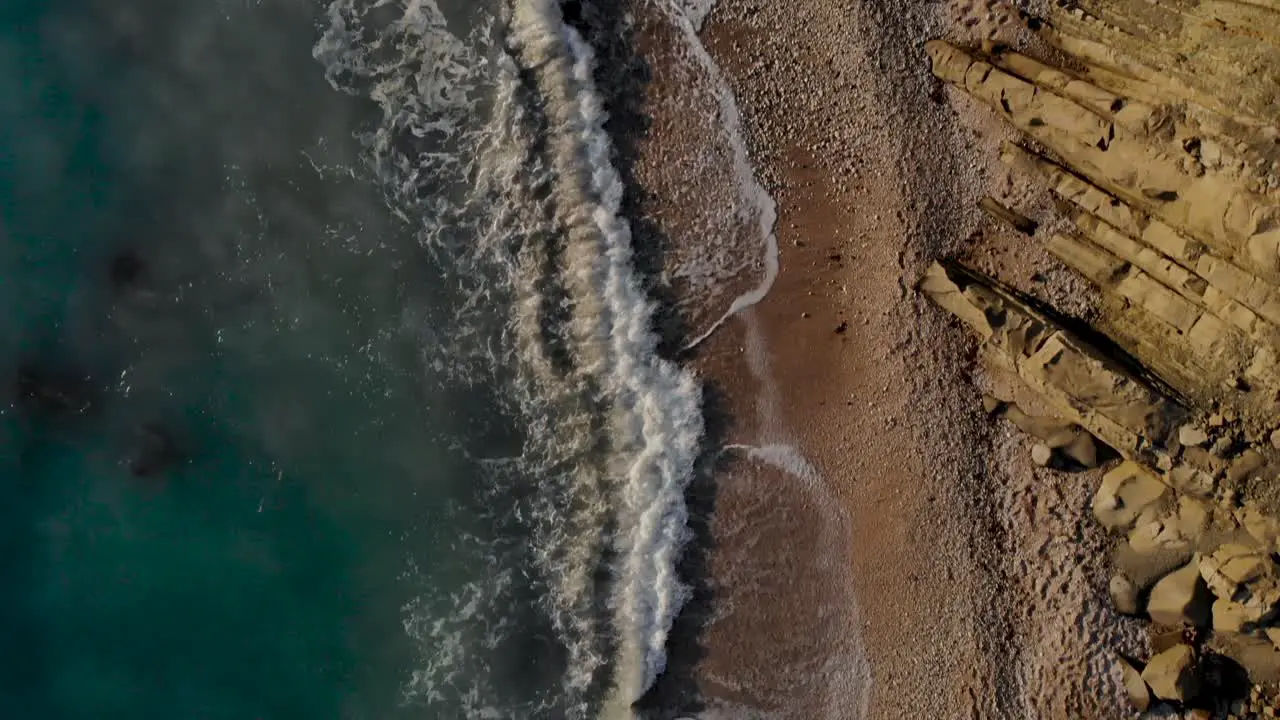 Sea waves splashing on cliffs and pebbles of beautiful coastline in Mediterranean