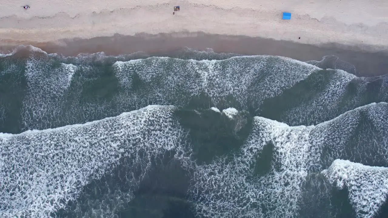 Aerial view of waves at the Barra Do Sahy beach in Brazil cenital drone shot