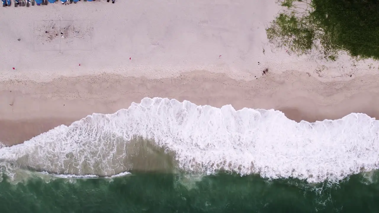 Topdown View Of Foamy Waves Breaking Over Sandy Shore In Phuket Thailand