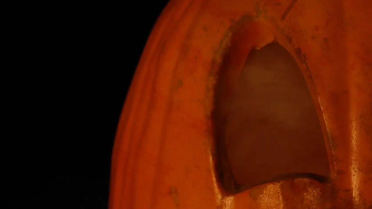 Close Up of Smoking Jack O Lantern Eye With Flickering Pumpkin Light Halloween