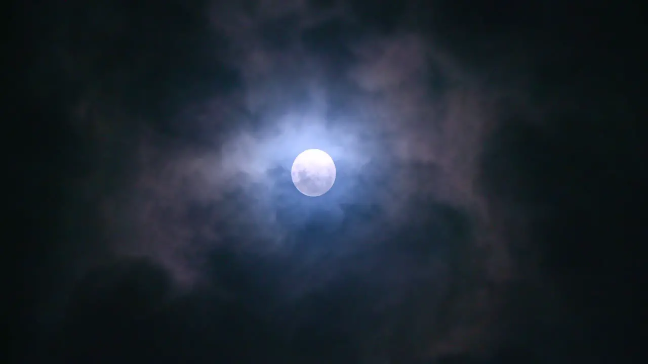 Full moon at night with clouds passing by