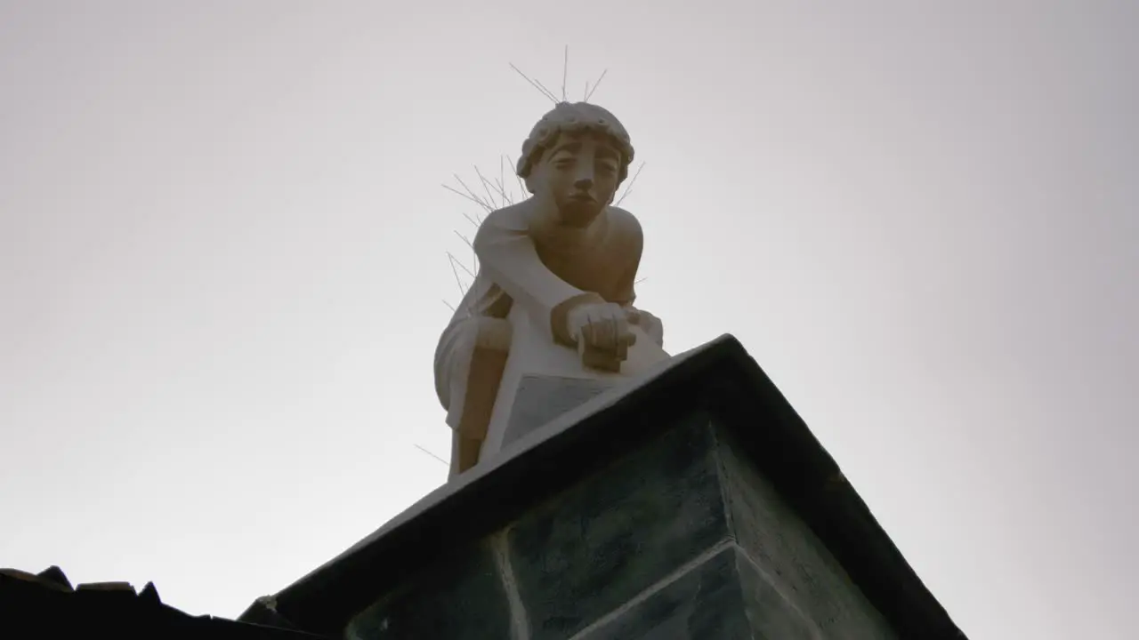 Stone statue of a child on top of a gothic old medieval church